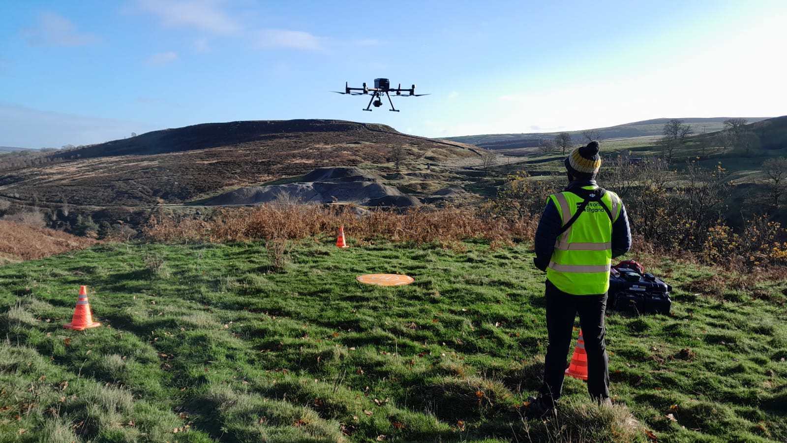 A drone being used in a rural environment, with an operator in the foreground